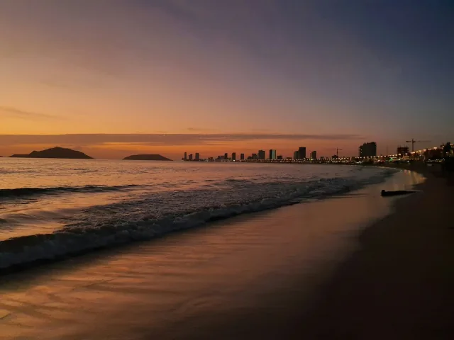 Atardecer en la playa de Mazatlán con la ciudad al fondo