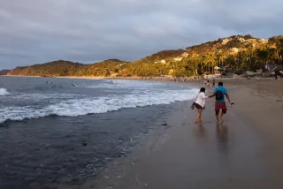 Personas caminando por la playa de Sayulita